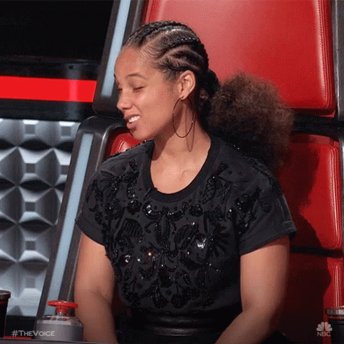 A Woman Wearing A Black Shirt And Hoop Earrings Is Sitting In A Chair With Her Eyes Closed .. GIF