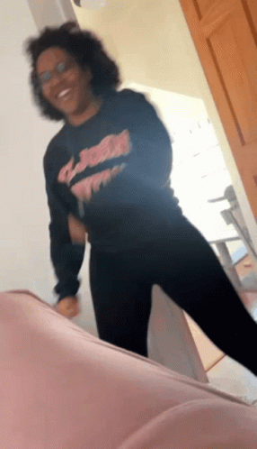 A Woman Wearing A Black Shirt That Says ' Jesus ' On It Is Dancing GIF
