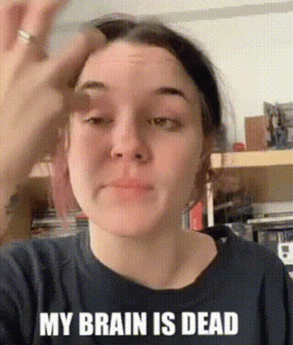 A Woman Wearing A Black Shirt That Says `` My Brain Is Dead '' Is Holding Her Hand To Her Forehead . GIF
