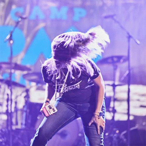 A Woman Wearing A Black Shirt That Says Stomn Is Dancing On Stage GIF