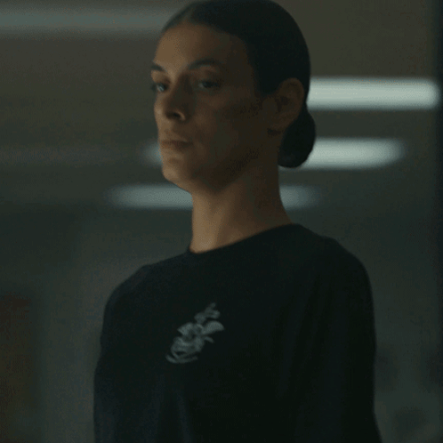 A Woman Wearing A Black Shirt With An Anchor On The Front GIF