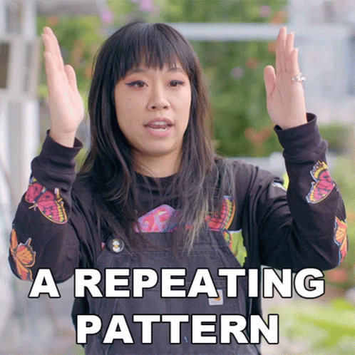A Woman Wearing A Black Shirt With Butterflies On It Says A Repeating Pattern With Her Hands In The Air GIF
