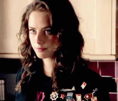 A Woman Wearing A Black Shirt With The Number 12 On It Is Standing In A Kitchen GIF