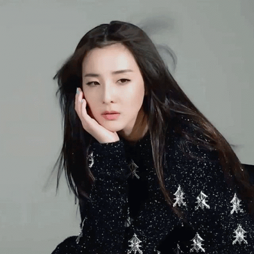 A Woman Wearing A Black Sweater With Silver Trees On It GIF