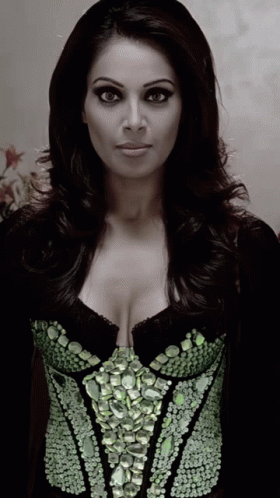 A Woman Wearing A Black Top With Green Rhinestones GIF