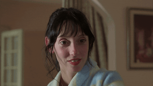 a woman wearing a blue and white striped robe smiles at the camera