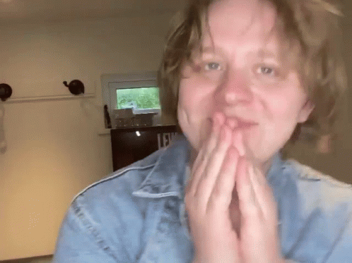A Woman Wearing A Blue Denim Jacket With The Letter L On It GIF