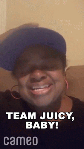 A Woman Wearing A Blue Hat And Earrings Is Smiling And Saying Team Juicy Baby . GIF