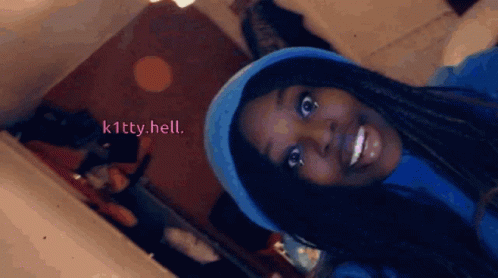 A Woman Wearing A Blue Hat Is Smiling With The Words K1tty.hell Written On The Bottom GIF