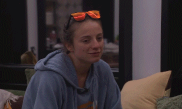 a woman wearing a blue hoodie and orange sunglasses