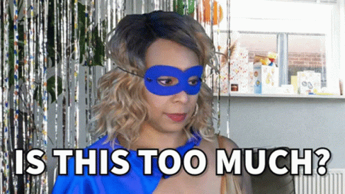 A Woman Wearing A Blue Mask With The Words Is This Too Much Behind Her GIF