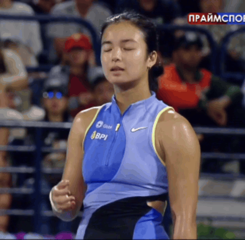 A Woman Wearing A Blue Nike Tank Top With Bpi Written On It GIF