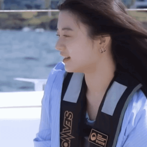 A Woman Wearing A Blue Shirt And A Black Vest That Says Seavest GIF