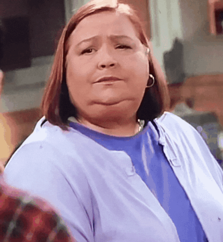 A Woman Wearing A Blue Shirt And A Purple Cardigan GIF