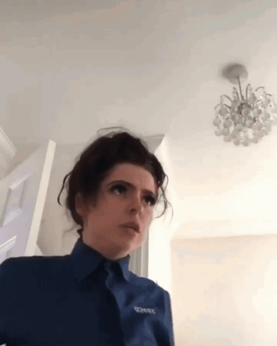 A Woman Wearing A Blue Shirt With The Word Corner On The Front GIF