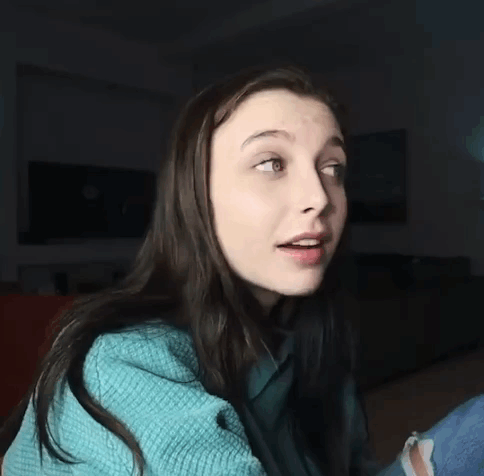 A Woman Wearing A Blue Sweater Is Making A Funny Face . GIF