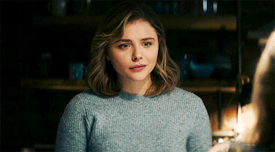 A Woman Wearing A Blue Sweater Looks At The Camera GIF