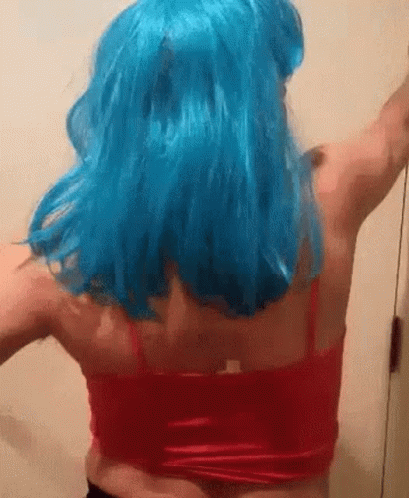 A Woman Wearing A Blue Wig And A Red Tank Top Is Dancing . GIF