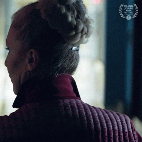 a woman wearing a braided bun is standing in front of a sign that says atlanta short film festival