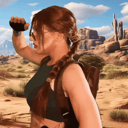 A Woman Wearing A Braided Ponytail And Sunglasses Stands In A Desert GIF