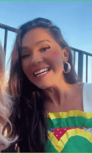 A Woman Wearing A Brazilian Flag Shirt And Hoop Earrings Smiles GIF