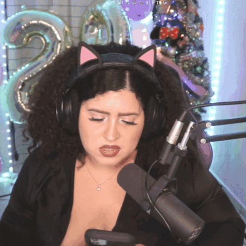 A Woman Wearing A Cat Ear Headband Looks At Her Phone GIF