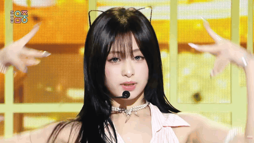 A Woman Wearing A Cat Ear Necklace And A Microphone On Stage . GIF