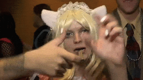 A Woman Wearing A Cat Ear Wig Is Being Touched By Someone 'S Hand GIF