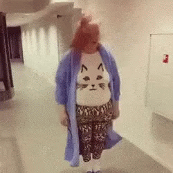 Woman In Cat Sweater Walking Down Hallway GIF