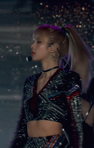 A Woman Wearing A Choker And A Crop Top Is Standing In Front Of A Microphone GIF