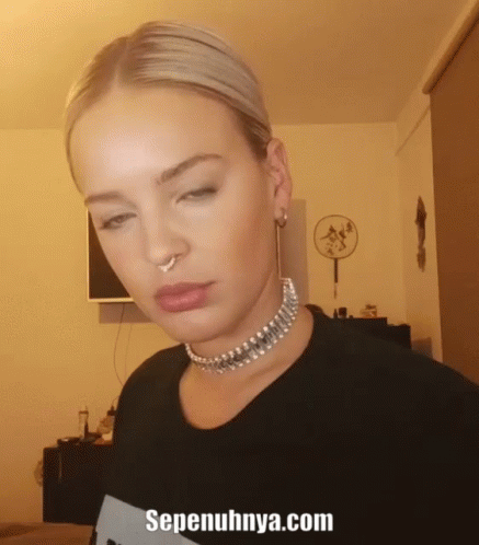A Woman Wearing A Choker And A Nose Ring With The Website Sepenuhnya.com Written Below Her GIF