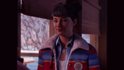 A Woman Wearing A Colorful Jacket And A Necklace With A Snowflake On It GIF