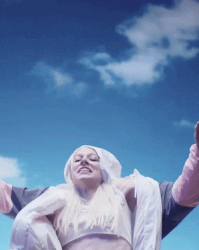 A Woman Wearing A Crop Top And A Hooded Jacket With The Word Nike On It GIF