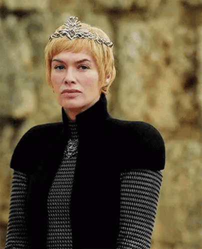A Woman Wearing A Crown And A Black Vest Is Standing In Front Of A Wall . GIF