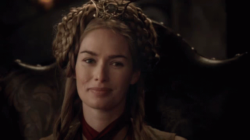 A Woman Wearing A Crown And A Red Scarf Is Smiling GIF