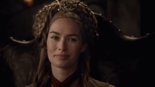 A Woman Wearing A Crown And A Red Scarf Is Smiling GIF