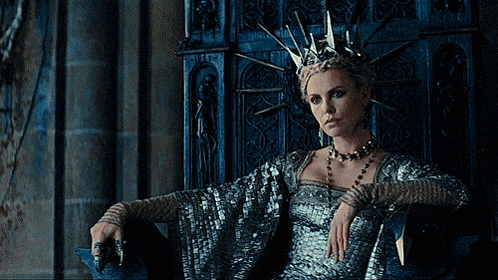 A Woman Wearing A Crown Sits In A Chair GIF