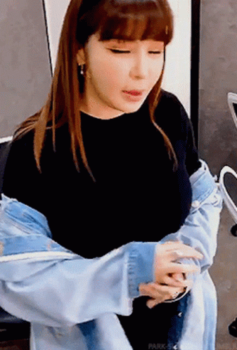 A Woman Wearing A Denim Jacket And A Black Shirt GIF