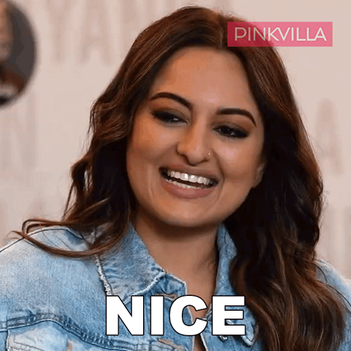 A Woman Wearing A Denim Jacket Is Smiling And The Word Nice Is Visible GIF