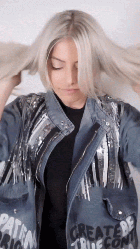 A Woman Wearing A Denim Jacket That Says Create Be True GIF