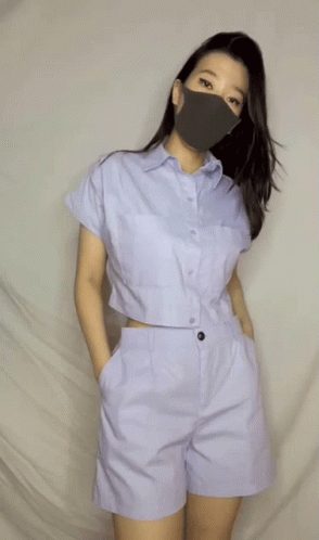 A Woman Wearing A Face Mask And A Crop Top GIF