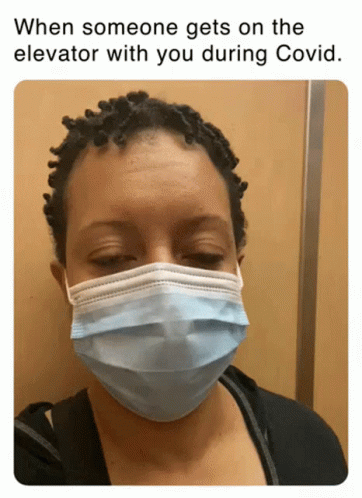 A Woman Wearing A Face Mask In An Elevator GIF