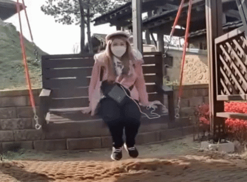 Woman Wearing Face Mask Sitting On Wooden Swing GIF