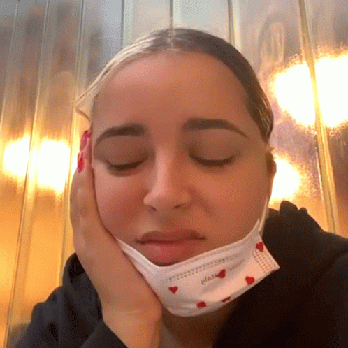 A Woman Wearing A Face Mask That Says Please GIF