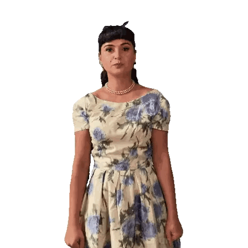 a woman wearing a floral dress and pearls is making a face
