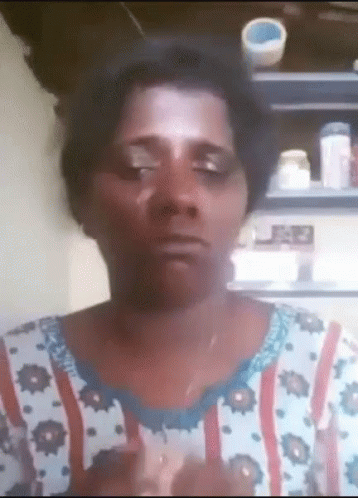 A Woman Wearing A Floral Shirt Is Making A Funny Face With Her Eyes Closed GIF