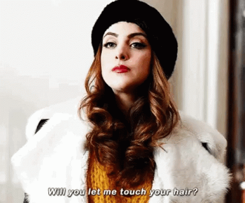 A Woman Wearing A Fur Coat And A Hat Is Talking To Another Woman . GIF