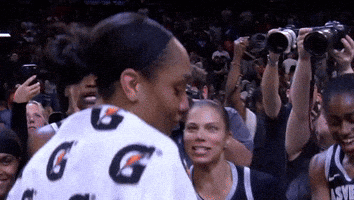 A Woman Wearing A Gatorade Shirt Stands In A Crowd GIF