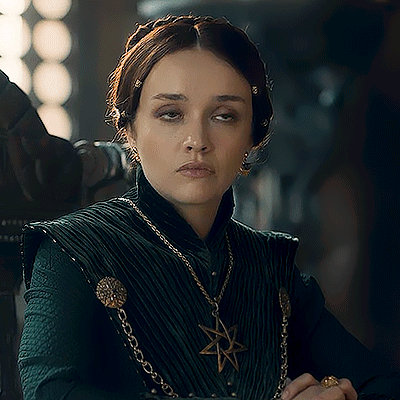 A Woman Wearing A Green Dress And A Gold Necklace With A Star Pendant GIF
