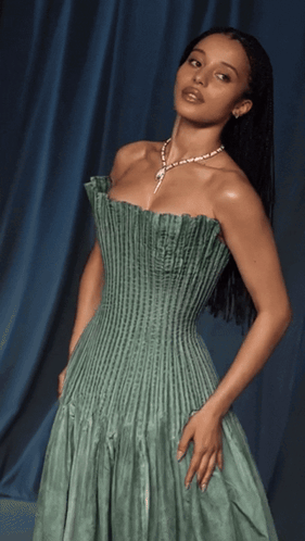 A Woman Wearing A Green Dress And A Necklace GIF